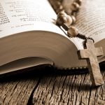 wooden rosary on the open Bible